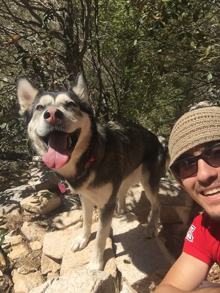 Coco smiling on a rocky hiking trail